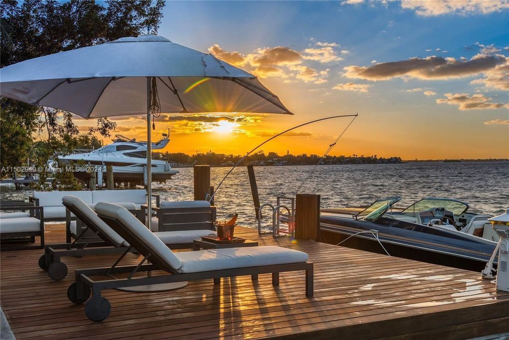 Discover unparalleled luxury in this modern masterpiece on guard-gated Biscayne Point Island. This exquisitely renovated home offers wide bay sunset views from a private peninsula with 360 feet of water frontage.