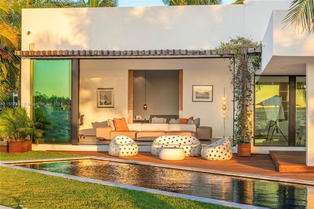 Discover unparalleled luxury in this modern masterpiece on guard-gated Biscayne Point Island. This exquisitely renovated home offers wide bay sunset views from a private peninsula with 360 feet of water frontage.