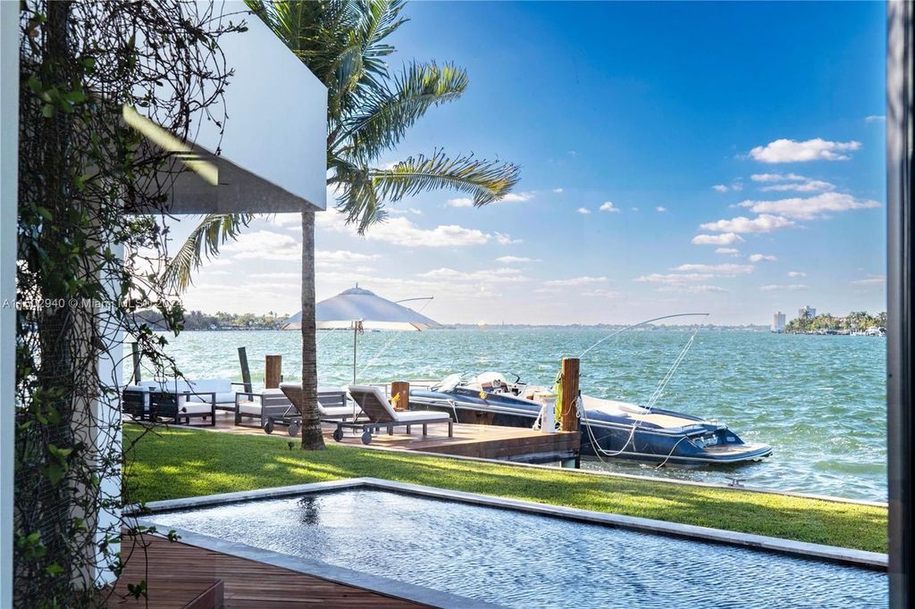Discover unparalleled luxury in this modern masterpiece on guard-gated Biscayne Point Island. This exquisitely renovated home offers wide bay sunset views from a private peninsula with 360 feet of water frontage.