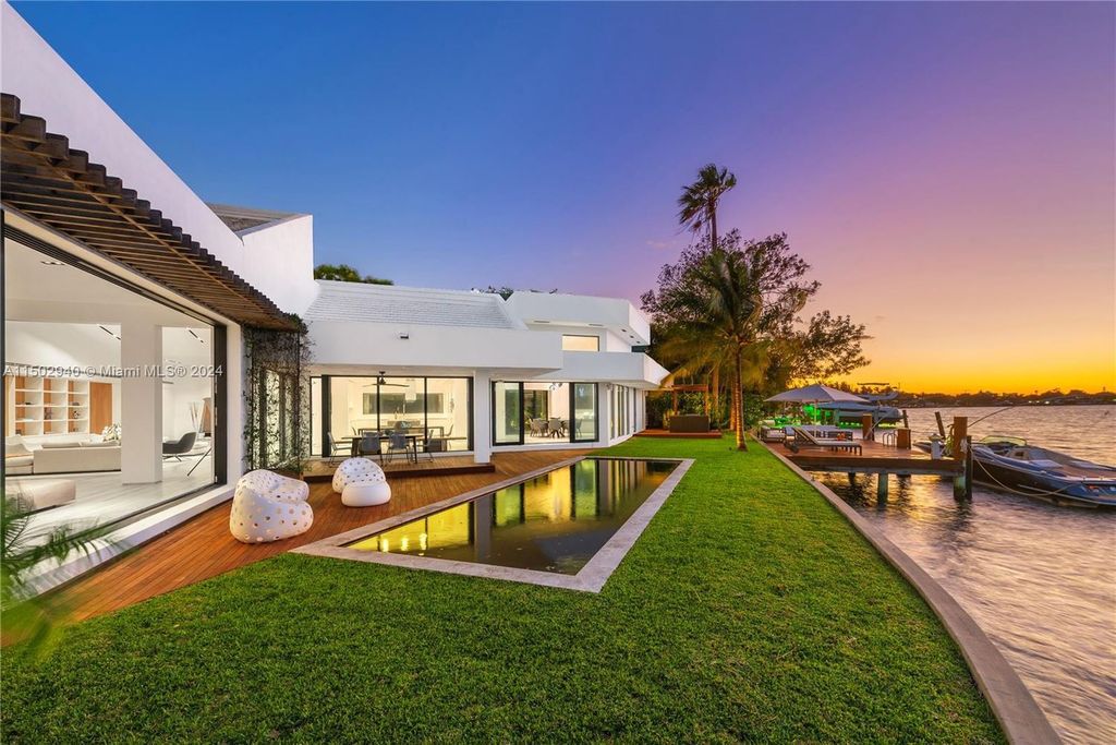 Discover unparalleled luxury in this modern masterpiece on guard-gated Biscayne Point Island. This exquisitely renovated home offers wide bay sunset views from a private peninsula with 360 feet of water frontage.