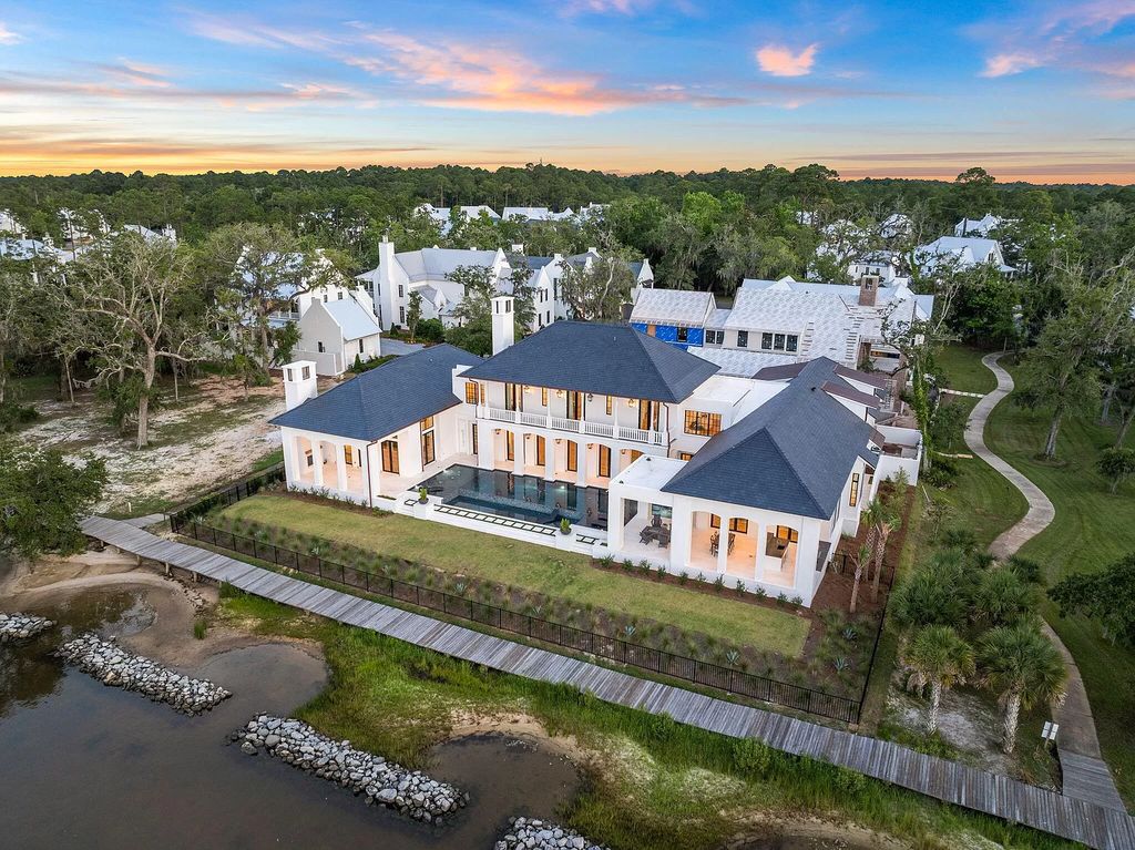 Nestled on a double homesite with 150'+ of Choctawhatchee Bay frontage in the prestigious gated enclave of Churchill Oaks, 51 Junop Court is a stunning legacy residence designed by Matt Savois and built by Grand Bay Construction.