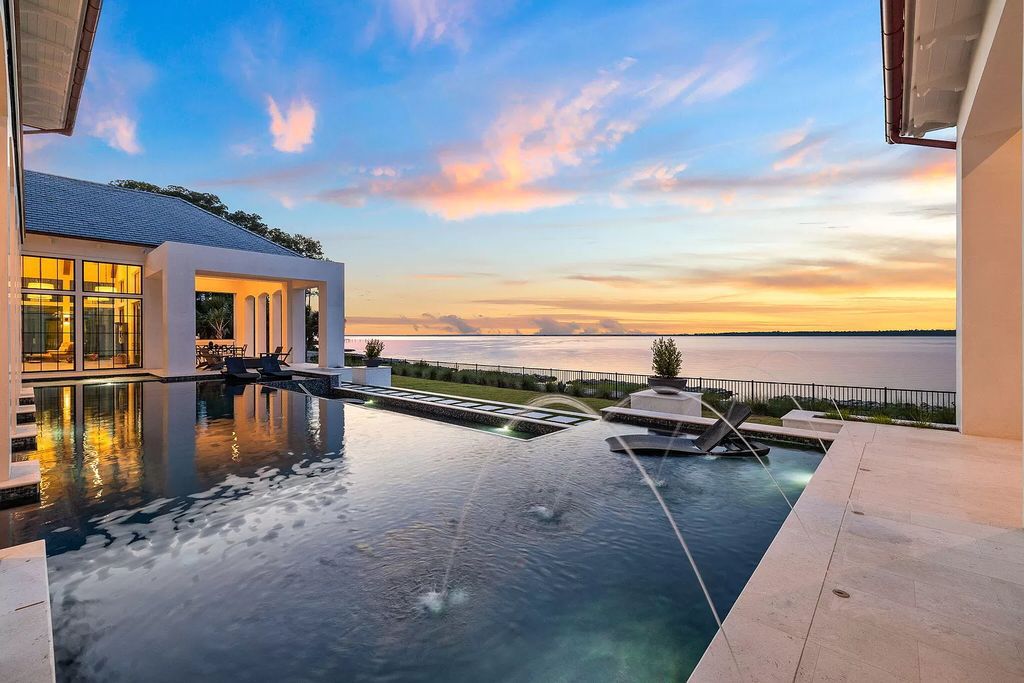Nestled on a double homesite with 150'+ of Choctawhatchee Bay frontage in the prestigious gated enclave of Churchill Oaks, 51 Junop Court is a stunning legacy residence designed by Matt Savois and built by Grand Bay Construction.