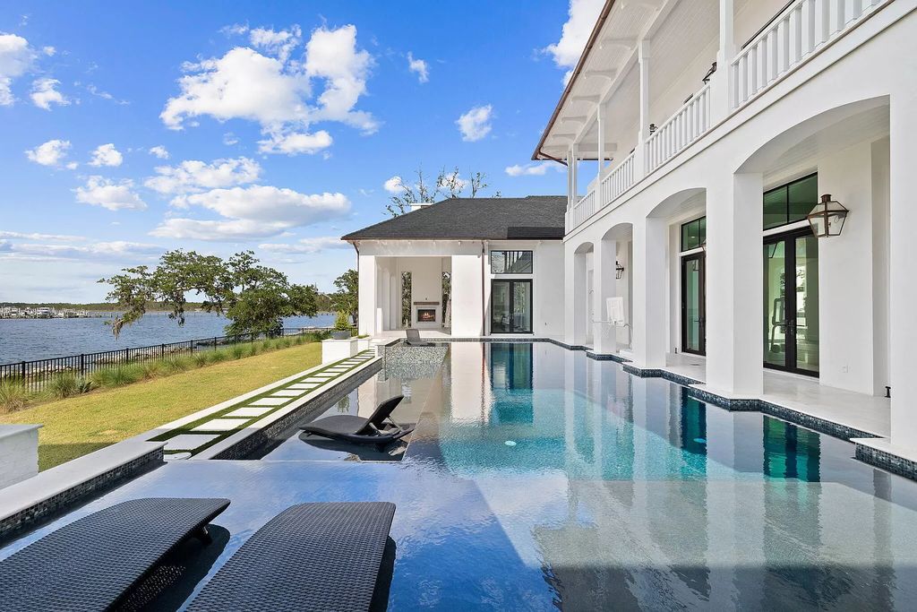 Nestled on a double homesite with 150'+ of Choctawhatchee Bay frontage in the prestigious gated enclave of Churchill Oaks, 51 Junop Court is a stunning legacy residence designed by Matt Savois and built by Grand Bay Construction.