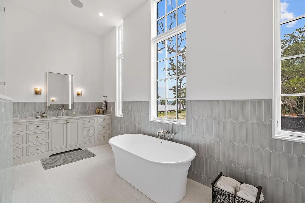 Nestled on a double homesite with 150'+ of Choctawhatchee Bay frontage in the prestigious gated enclave of Churchill Oaks, 51 Junop Court is a stunning legacy residence designed by Matt Savois and built by Grand Bay Construction.
