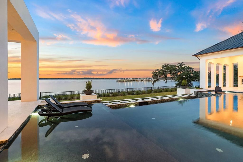 Nestled on a double homesite with 150'+ of Choctawhatchee Bay frontage in the prestigious gated enclave of Churchill Oaks, 51 Junop Court is a stunning legacy residence designed by Matt Savois and built by Grand Bay Construction.