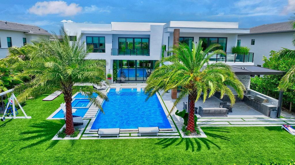 Welcome to this lavish modern luxury estate in the prestigious Boca Bridges. This distinguished "Dali" contemporary masterpiece, one of only seven, spans 8,000 square feet on a large waterfront lot.