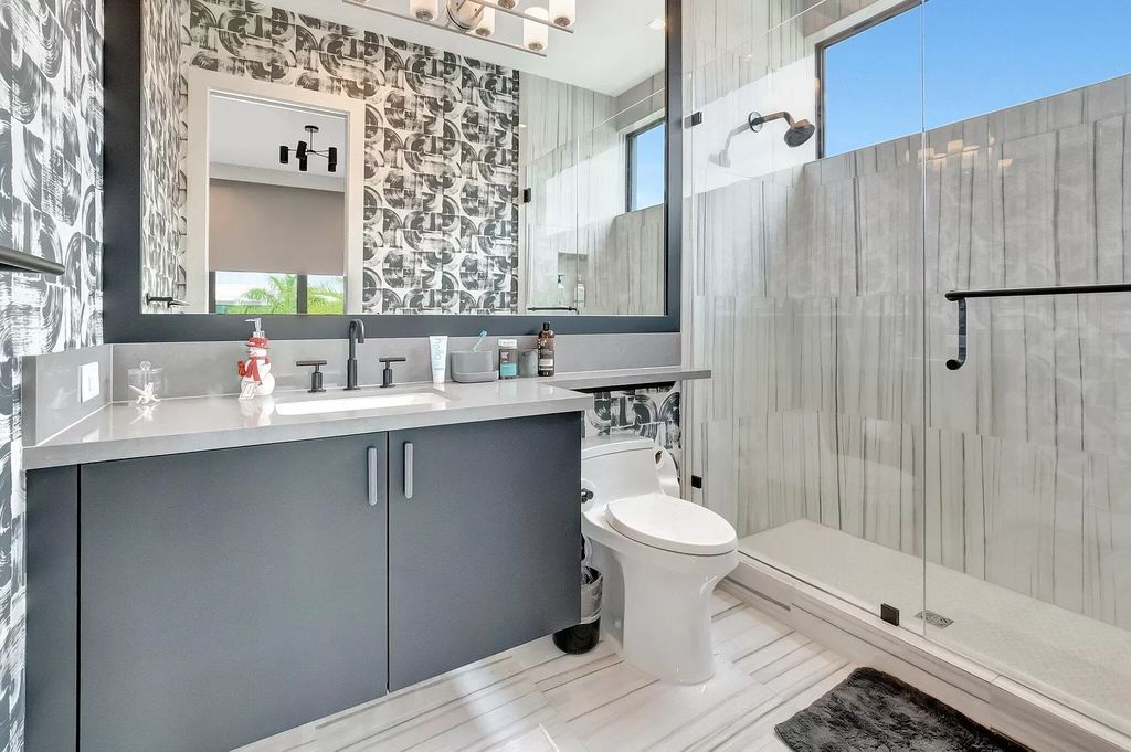 Welcome to this lavish modern luxury estate in the prestigious Boca Bridges. This distinguished "Dali" contemporary masterpiece, one of only seven, spans 8,000 square feet on a large waterfront lot.