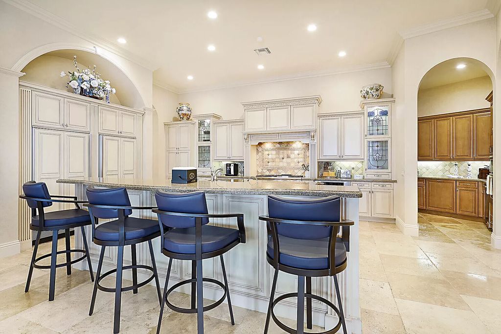 This dream home features a home office, theater, chef's kitchen with high-end appliances, dual-zone wine refrigerators, and lavish architectural details.