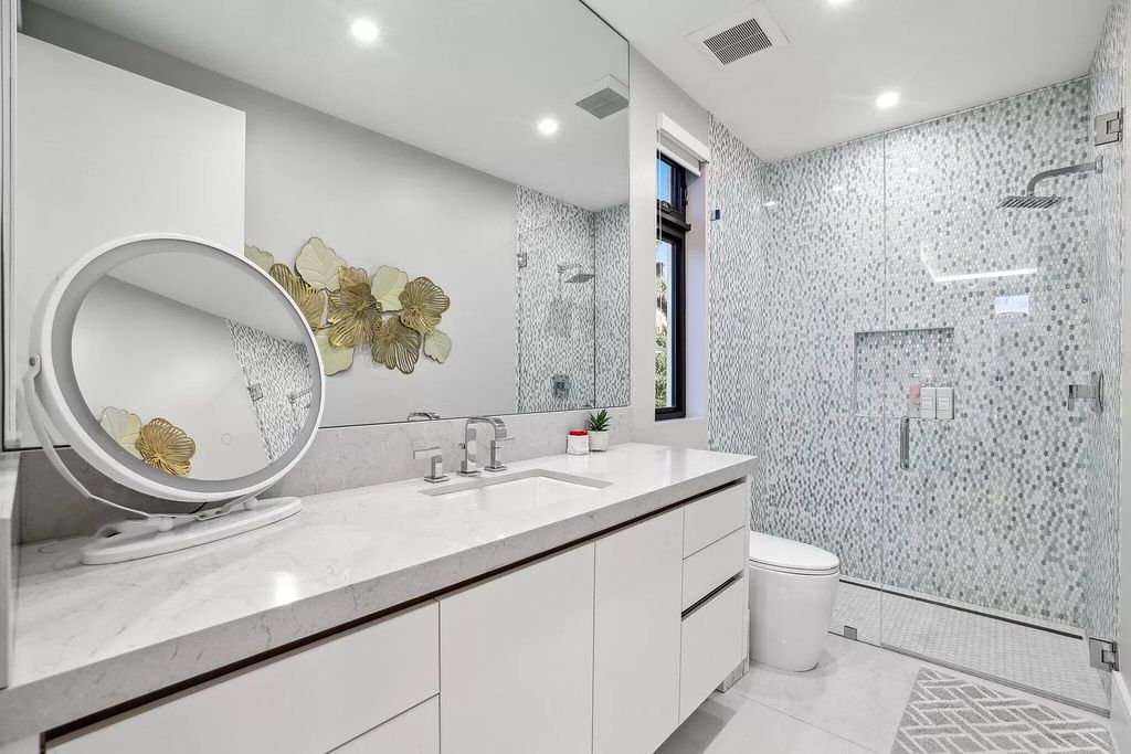 This 5-bed, 7-bath masterpiece, built in 2021, spans over 6,159 sq ft on a 0.30-acre lot. Highlights include a 2-story great room with stunning glass walls and a gas fireplace, a formal dining room with a glass wine closet, a custom kitchen with double-thick quartzite countertops, Miele appliances, and Carrara porcelain tiles.