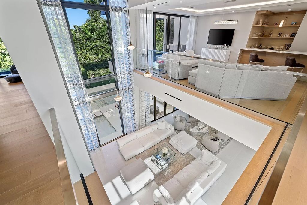 This 5-bed, 7-bath masterpiece, built in 2021, spans over 6,159 sq ft on a 0.30-acre lot. Highlights include a 2-story great room with stunning glass walls and a gas fireplace, a formal dining room with a glass wine closet, a custom kitchen with double-thick quartzite countertops, Miele appliances, and Carrara porcelain tiles.