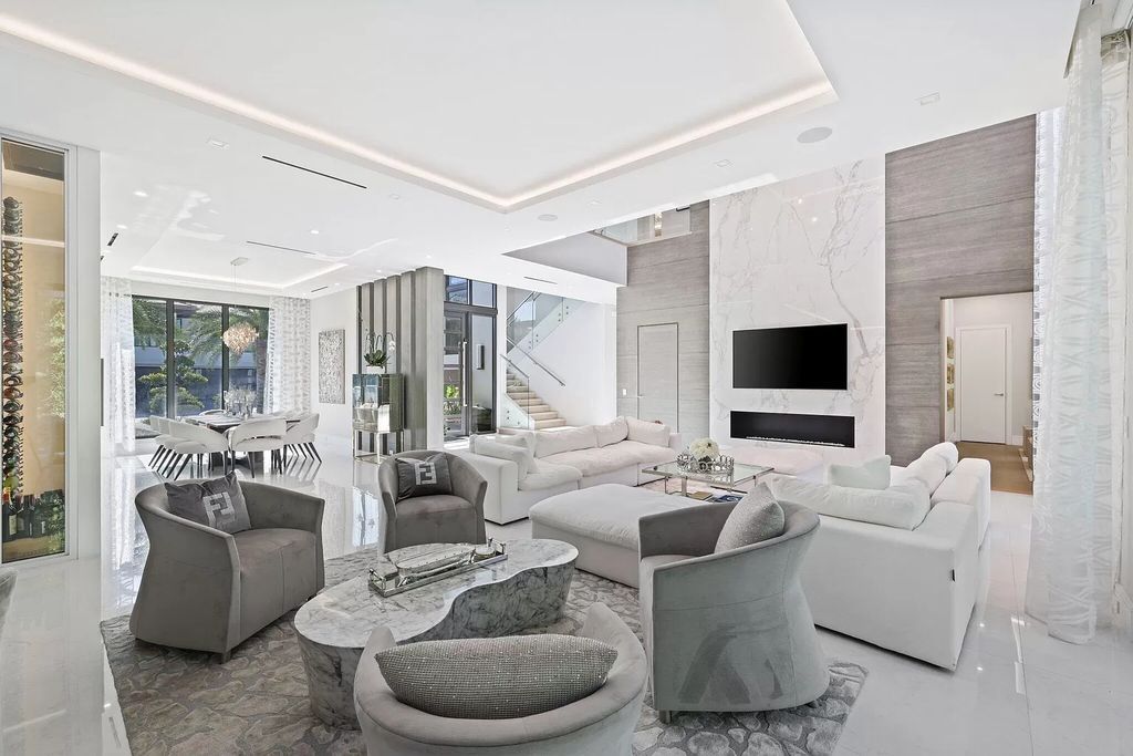 This 5-bed, 7-bath masterpiece, built in 2021, spans over 6,159 sq ft on a 0.30-acre lot. Highlights include a 2-story great room with stunning glass walls and a gas fireplace, a formal dining room with a glass wine closet, a custom kitchen with double-thick quartzite countertops, Miele appliances, and Carrara porcelain tiles.