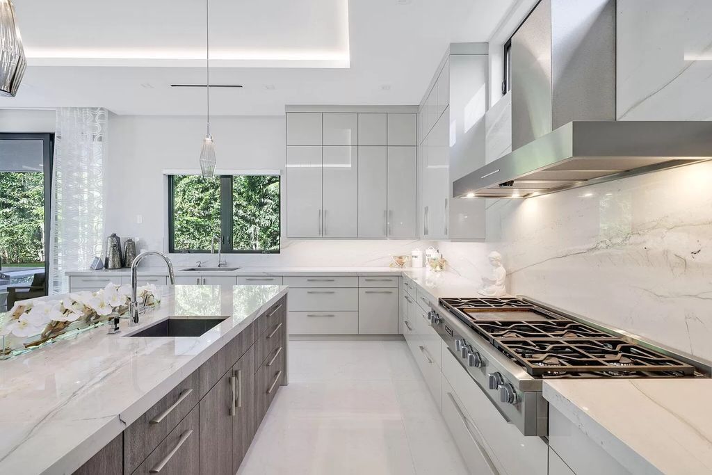 This 5-bed, 7-bath masterpiece, built in 2021, spans over 6,159 sq ft on a 0.30-acre lot. Highlights include a 2-story great room with stunning glass walls and a gas fireplace, a formal dining room with a glass wine closet, a custom kitchen with double-thick quartzite countertops, Miele appliances, and Carrara porcelain tiles.