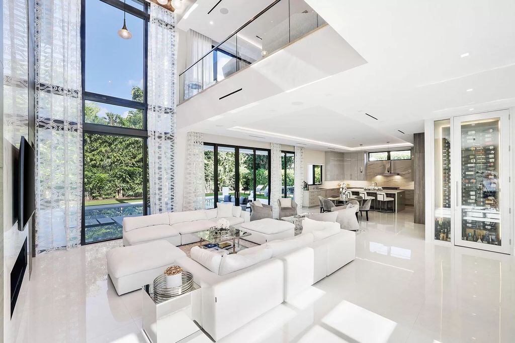 This 5-bed, 7-bath masterpiece, built in 2021, spans over 6,159 sq ft on a 0.30-acre lot. Highlights include a 2-story great room with stunning glass walls and a gas fireplace, a formal dining room with a glass wine closet, a custom kitchen with double-thick quartzite countertops, Miele appliances, and Carrara porcelain tiles.
