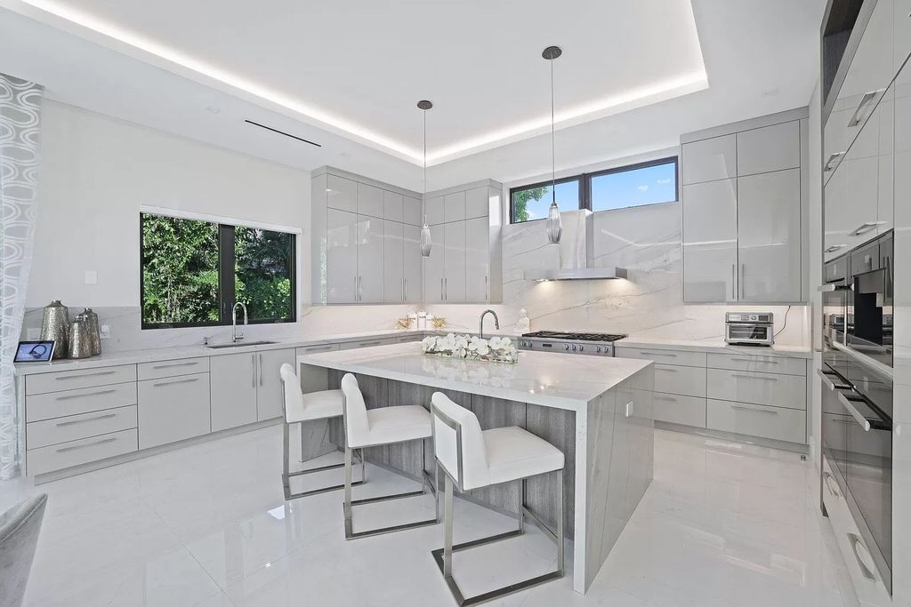 This 5-bed, 7-bath masterpiece, built in 2021, spans over 6,159 sq ft on a 0.30-acre lot. Highlights include a 2-story great room with stunning glass walls and a gas fireplace, a formal dining room with a glass wine closet, a custom kitchen with double-thick quartzite countertops, Miele appliances, and Carrara porcelain tiles.