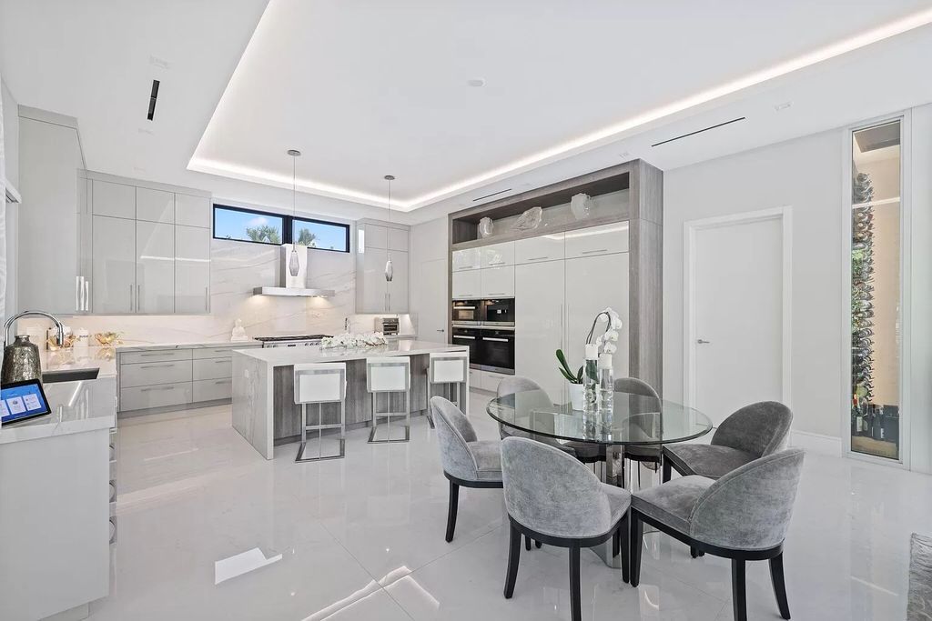 This 5-bed, 7-bath masterpiece, built in 2021, spans over 6,159 sq ft on a 0.30-acre lot. Highlights include a 2-story great room with stunning glass walls and a gas fireplace, a formal dining room with a glass wine closet, a custom kitchen with double-thick quartzite countertops, Miele appliances, and Carrara porcelain tiles.