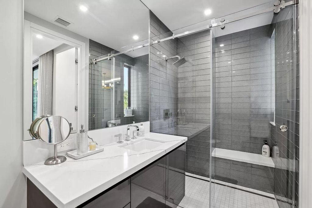 This 5-bed, 7-bath masterpiece, built in 2021, spans over 6,159 sq ft on a 0.30-acre lot. Highlights include a 2-story great room with stunning glass walls and a gas fireplace, a formal dining room with a glass wine closet, a custom kitchen with double-thick quartzite countertops, Miele appliances, and Carrara porcelain tiles.