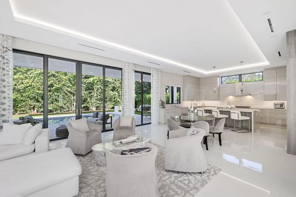 This 5-bed, 7-bath masterpiece, built in 2021, spans over 6,159 sq ft on a 0.30-acre lot. Highlights include a 2-story great room with stunning glass walls and a gas fireplace, a formal dining room with a glass wine closet, a custom kitchen with double-thick quartzite countertops, Miele appliances, and Carrara porcelain tiles.