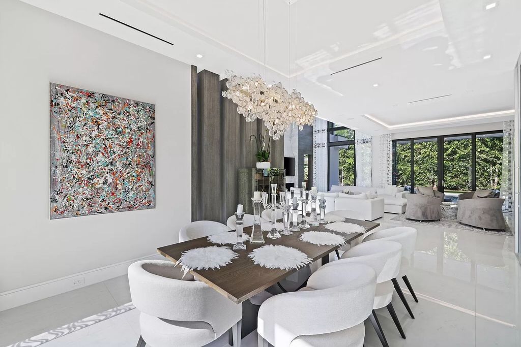 This 5-bed, 7-bath masterpiece, built in 2021, spans over 6,159 sq ft on a 0.30-acre lot. Highlights include a 2-story great room with stunning glass walls and a gas fireplace, a formal dining room with a glass wine closet, a custom kitchen with double-thick quartzite countertops, Miele appliances, and Carrara porcelain tiles.