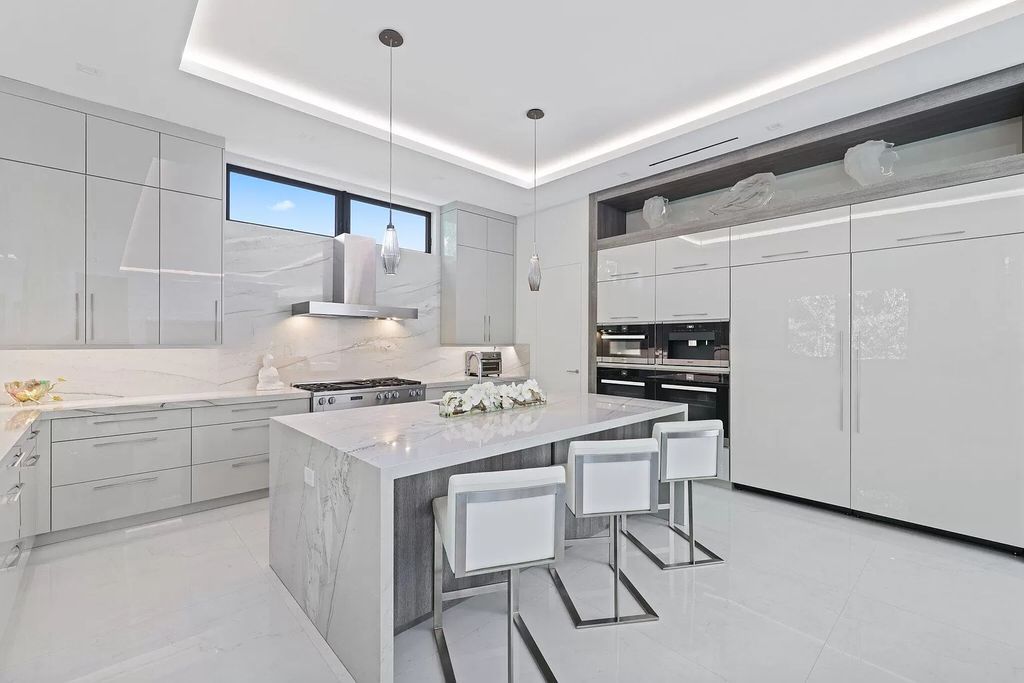 This 5-bed, 7-bath masterpiece, built in 2021, spans over 6,159 sq ft on a 0.30-acre lot. Highlights include a 2-story great room with stunning glass walls and a gas fireplace, a formal dining room with a glass wine closet, a custom kitchen with double-thick quartzite countertops, Miele appliances, and Carrara porcelain tiles.
