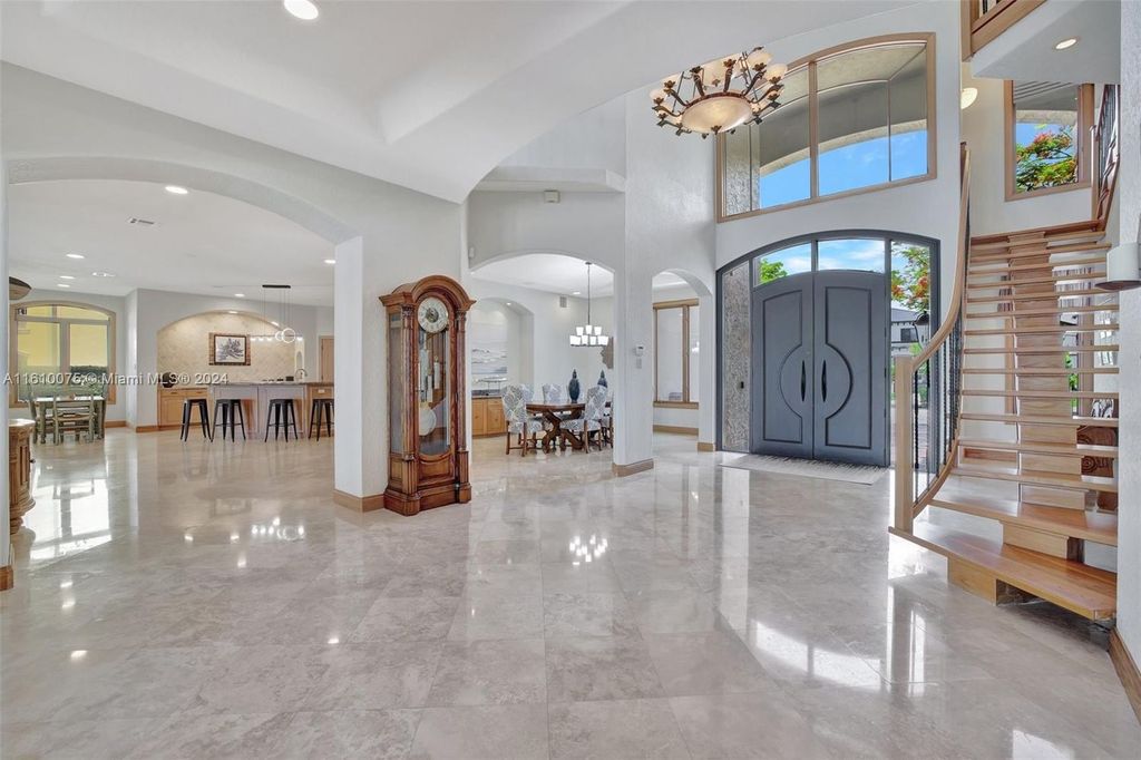 A boater's dream, the estate sits on a 12,651 square feet lot with a 2,000 square feet dock and boat lift. The 6,788 square feet home features generous living areas, an elevator, and an expansive second-floor terrace with an oversized primary bedroom, loft, and office den.