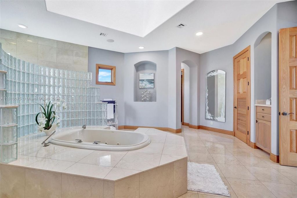 A boater's dream, the estate sits on a 12,651 square feet lot with a 2,000 square feet dock and boat lift. The 6,788 square feet home features generous living areas, an elevator, and an expansive second-floor terrace with an oversized primary bedroom, loft, and office den.