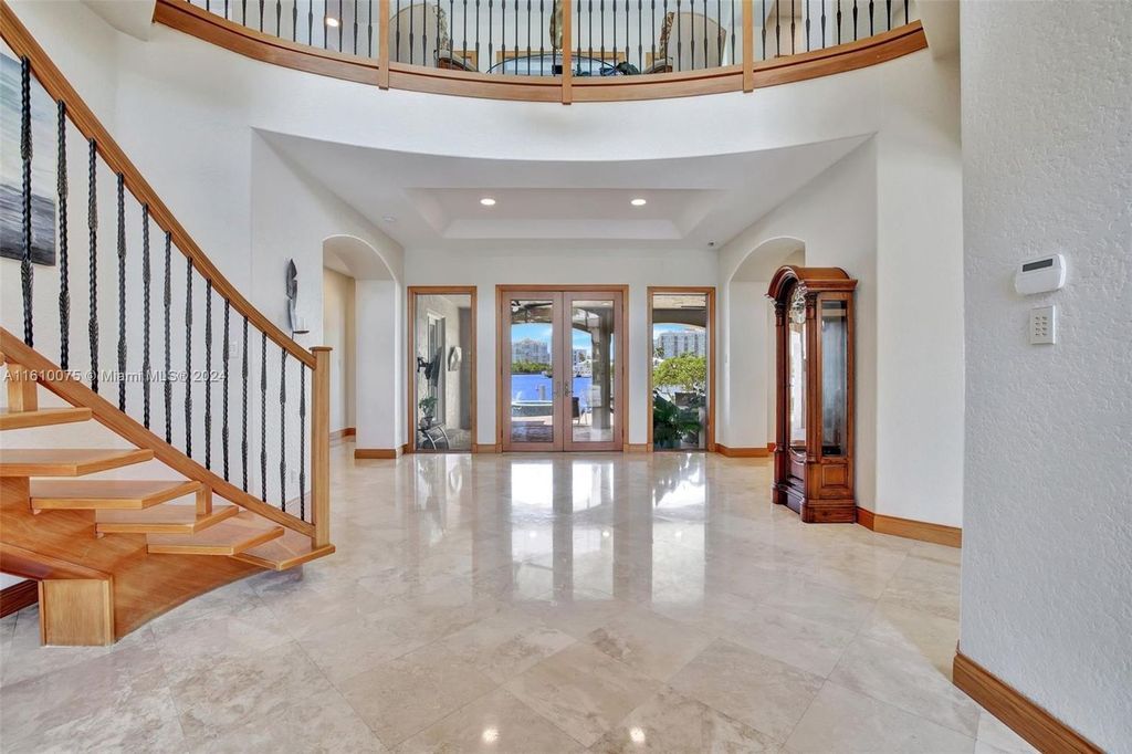A boater's dream, the estate sits on a 12,651 square feet lot with a 2,000 square feet dock and boat lift. The 6,788 square feet home features generous living areas, an elevator, and an expansive second-floor terrace with an oversized primary bedroom, loft, and office den.