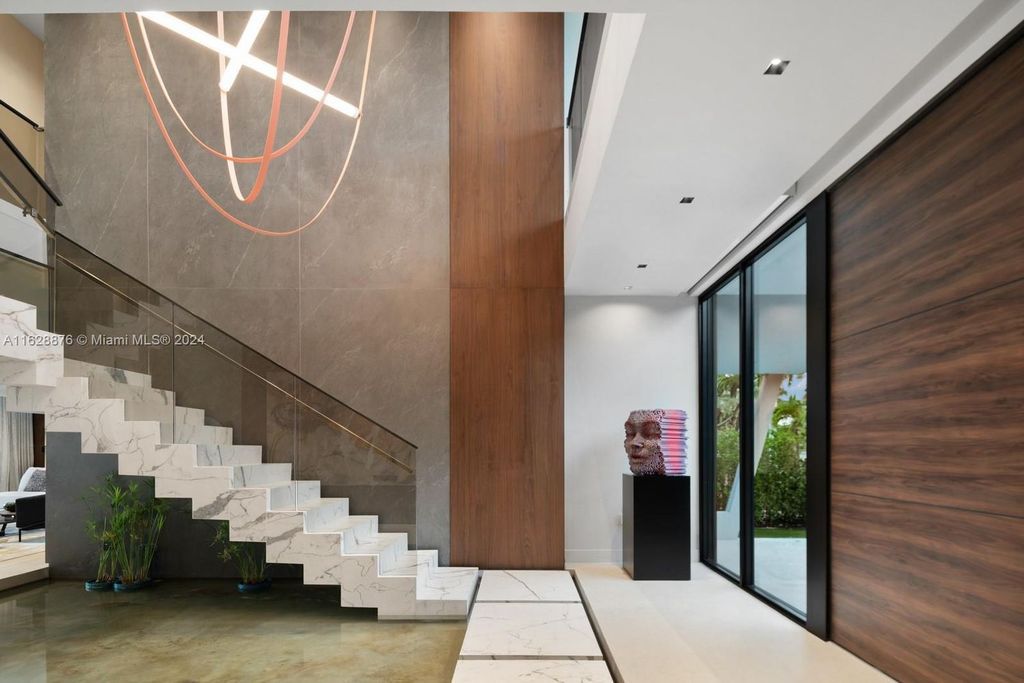 Discover an extraordinary waterfront compound in gated San Souci Estates, featuring a brand new ultra-modern home and a sophisticated guest house on a double lot.