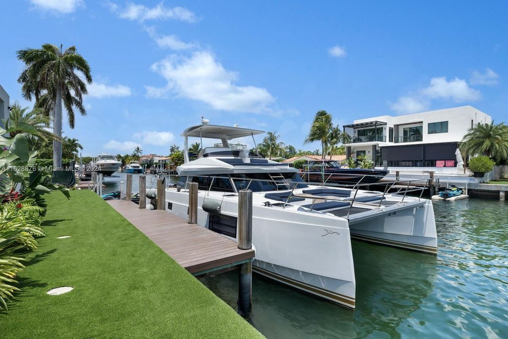Discover an extraordinary waterfront compound in gated San Souci Estates, featuring a brand new ultra-modern home and a sophisticated guest house on a double lot.