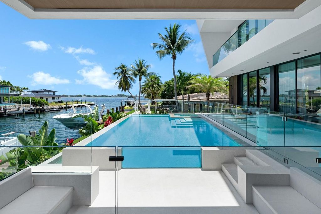 Discover an extraordinary waterfront compound in gated San Souci Estates, featuring a brand new ultra-modern home and a sophisticated guest house on a double lot.