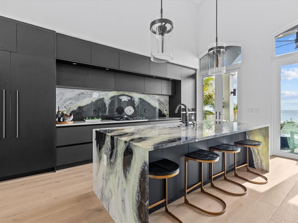 Enjoy modern elegance with breathtaking ocean views, a gourmet kitchen with marble countertops, a state-of-the-art water vapor fireplace, and over 10 TVs.