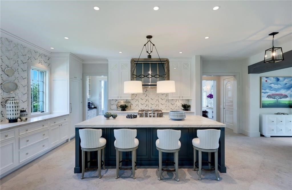 Set on nearly an acre in Audubon Country Club, this 4-bed, 6-bath home, designed by Renee Gaddis and built by the Williams Group, blends modern art deco with French countryside charm.