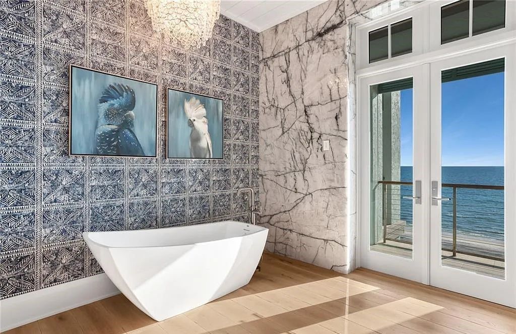 Nestled in the exclusive Strand at Bay Colony, this newly constructed 2023 custom home offers 5 bedrooms, 6 baths, and 7,210 square feet of refined living space on a 0.60-acre beachfront lot.