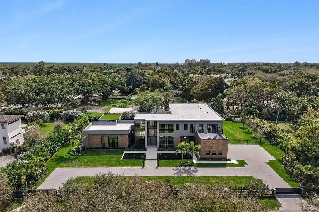Luxury modern estate at 5900 SW 129th Terrace, Pinecrest, FL – a $17.99M newly built home featuring a pristine pool, private gym, immersive theater, and elegant open kitchen.