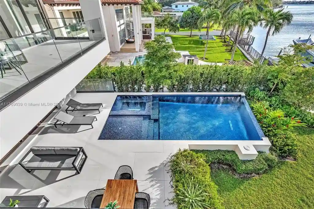 Open-concept living area with floor-to-ceiling windows at 9056 Bay Dr Surfside home for sale