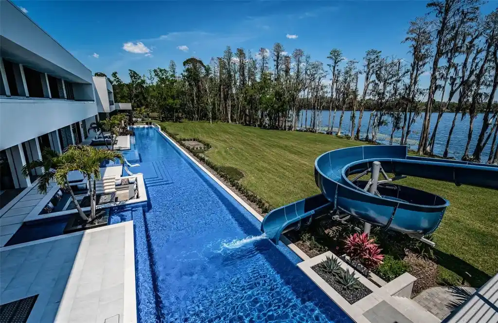 Infinity-edge pool designed by Ryan Hughes at 18725 Jiretz Rd with lake views and fiber optic lighting.