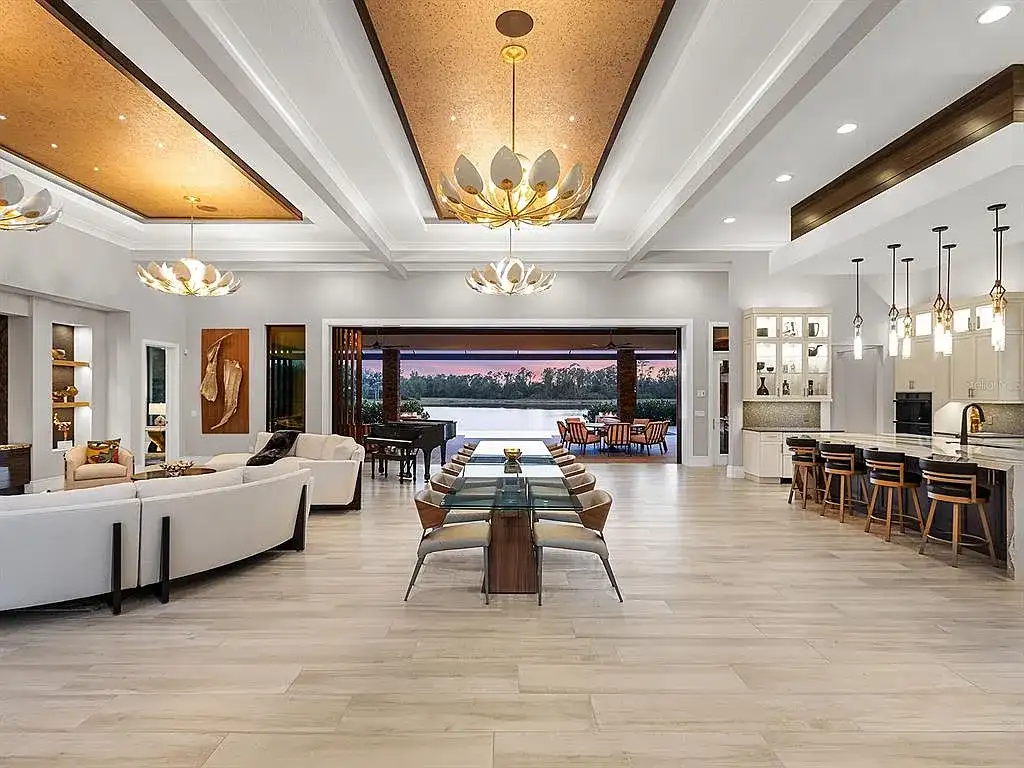 Front view of the stunning $7.5M custom lakefront estate at 18826 Ganton Ave in The Concession, Bradenton, showcasing grand circular driveway and elegant stone columns.