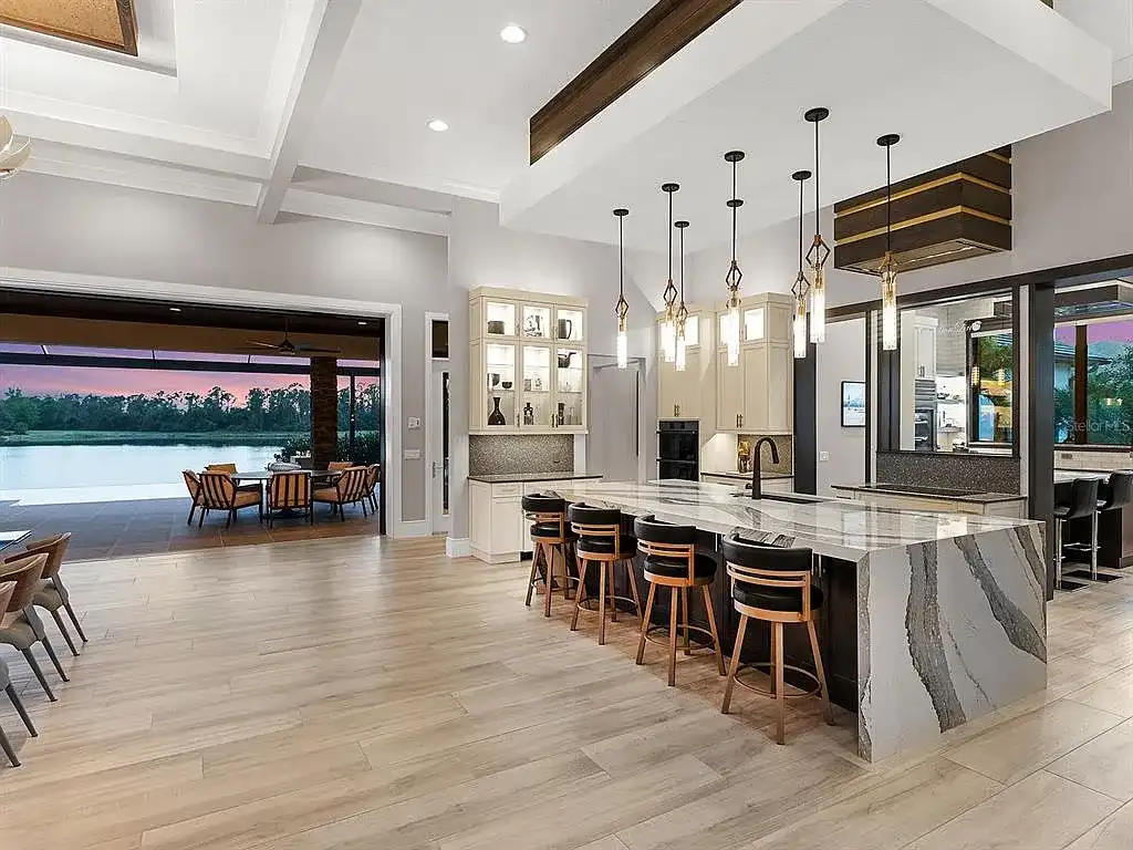 Front view of the stunning $7.5M custom lakefront estate at 18826 Ganton Ave in The Concession, Bradenton, showcasing grand circular driveway and elegant stone columns.