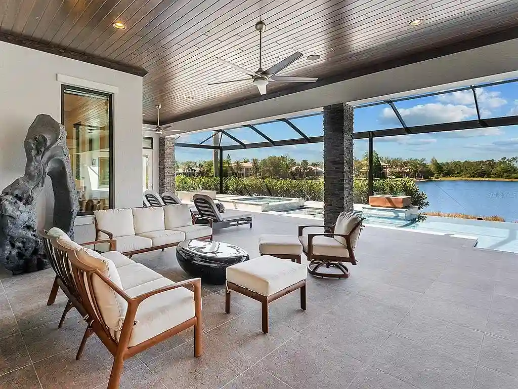 Front view of the stunning $7.5M custom lakefront estate at 18826 Ganton Ave in The Concession, Bradenton, showcasing grand circular driveway and elegant stone columns.