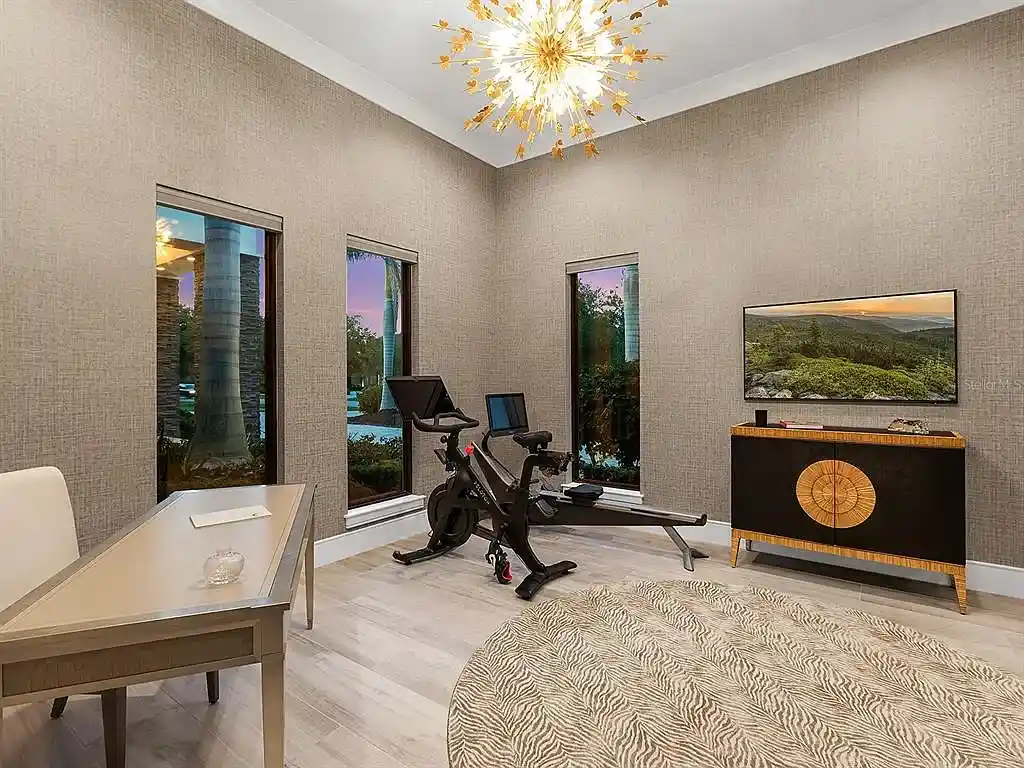 Front view of the stunning $7.5M custom lakefront estate at 18826 Ganton Ave in The Concession, Bradenton, showcasing grand circular driveway and elegant stone columns.