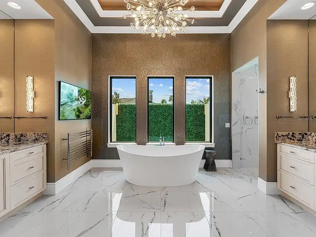 Front view of the stunning $7.5M custom lakefront estate at 18826 Ganton Ave in The Concession, Bradenton, showcasing grand circular driveway and elegant stone columns.