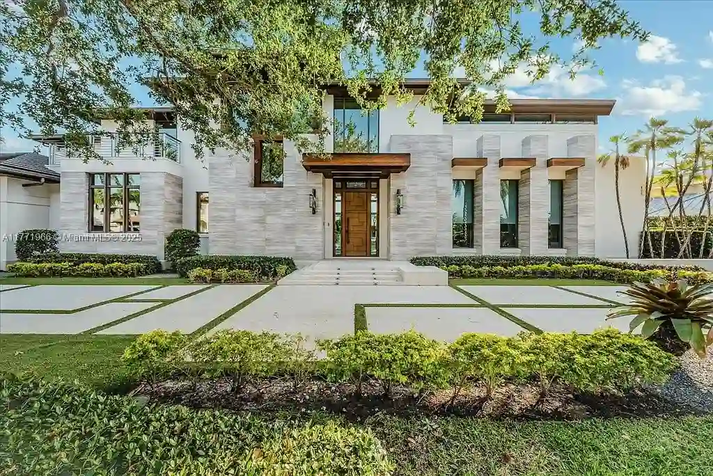 Luxurious waterfront mansion at 20 Compass Isle in Fort Lauderdale with tropical landscaping and gated driveway