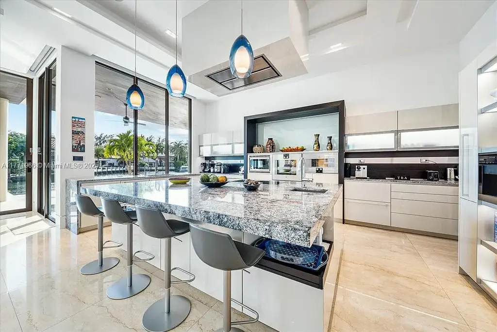 Luxurious waterfront mansion at 20 Compass Isle in Fort Lauderdale with tropical landscaping and gated driveway