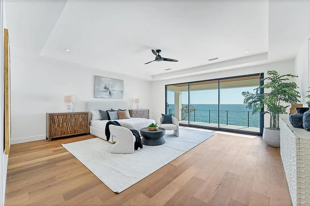 Exterior view of 4005 Casey Key Rd, a $11.9 million modern Gulf-front estate in Nokomis, Florida, featuring a rooftop terrace, oceanfront pool, and lush tropical landscaping
