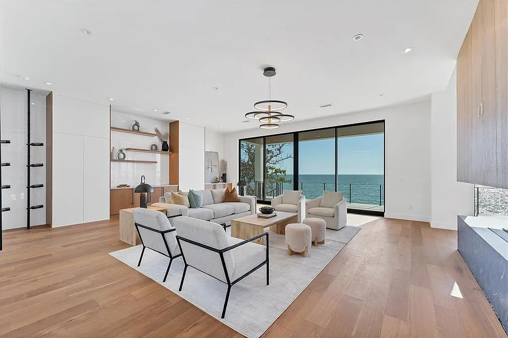 Exterior view of 4005 Casey Key Rd, a $11.9 million modern Gulf-front estate in Nokomis, Florida, featuring a rooftop terrace, oceanfront pool, and lush tropical landscaping