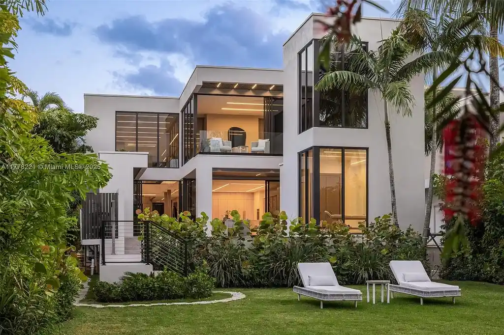 Luxury waterfront home at 725 NE 77th St, Miami featuring private dock, heated pool, modern architecture, and lush landscaping in Belle Meade