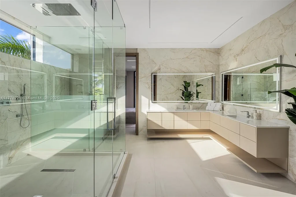 Luxury waterfront home at 725 NE 77th St, Miami featuring private dock, heated pool, modern architecture, and lush landscaping in Belle Meade