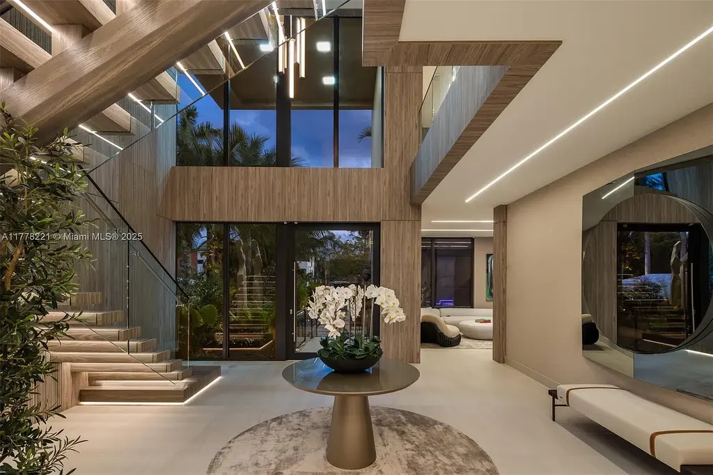 Luxury waterfront home at 725 NE 77th St, Miami featuring private dock, heated pool, modern architecture, and lush landscaping in Belle Meade