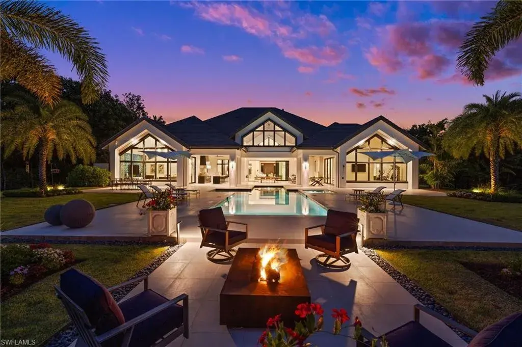 Luxury estate at 115 East Ave in Naples featuring outdoor kitchen, screened lanai, fire pit, and heated saltwater pool within Pine Ridge Estates