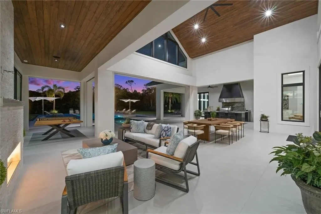 Luxury estate at 115 East Ave in Naples featuring outdoor kitchen, screened lanai, fire pit, and heated saltwater pool within Pine Ridge Estates