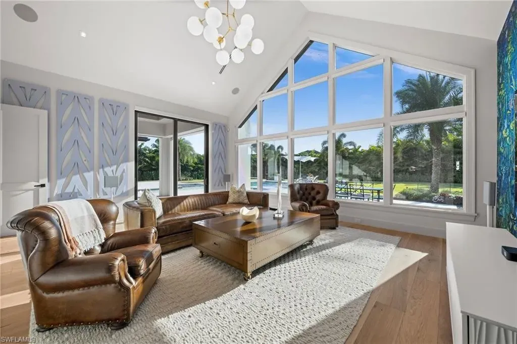 Luxury estate at 115 East Ave in Naples featuring outdoor kitchen, screened lanai, fire pit, and heated saltwater pool within Pine Ridge Estates